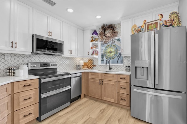 2009 Woodward Ave, Dunedin, FL 34698 - kitchen featuring stainless steel appliances, light wood-type flooring, light countertops, decorative backsplash, and recessed lighting