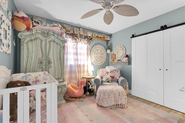2009 Woodward Ave, Dunedin, FL 34698 - bedroom featuring a barn door, wood finished floors, and a ceiling fan