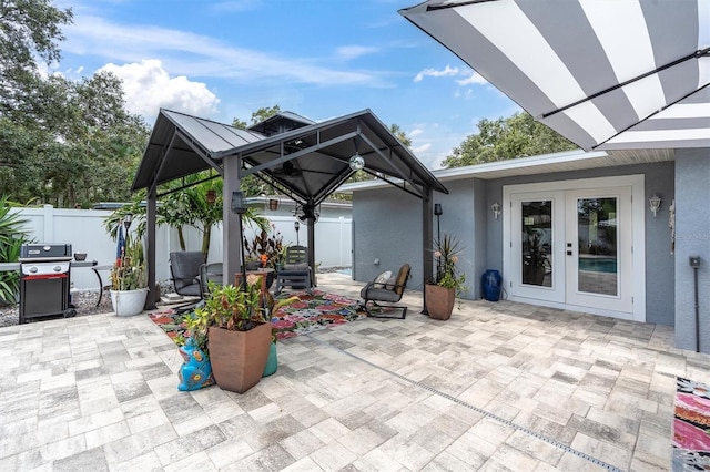 2009 Woodward Ave, Dunedin, FL 34698 - fenced backyard with french doors, a patio area, a gazebo, and a grill