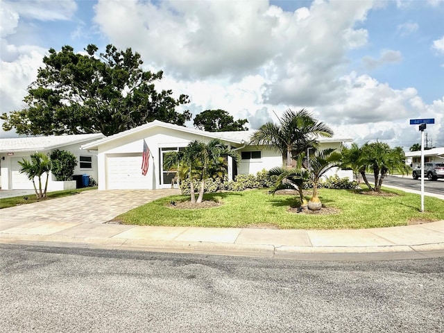 9830 44th Way N, Pinellas Park, FL 33782 - view of front facade with a garage, a front lawn, driveway, and stucco siding
