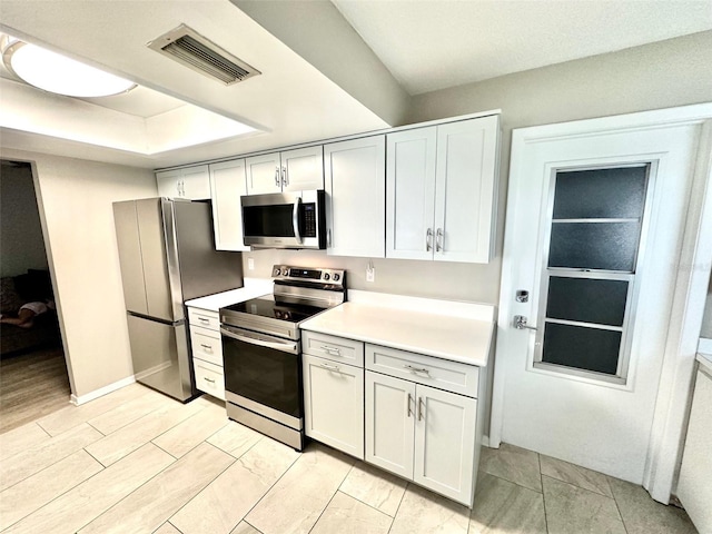 9830 44th Way N, Pinellas Park, FL 33782 - kitchen featuring appliances with stainless steel finishes, light countertops, and a raised ceiling
