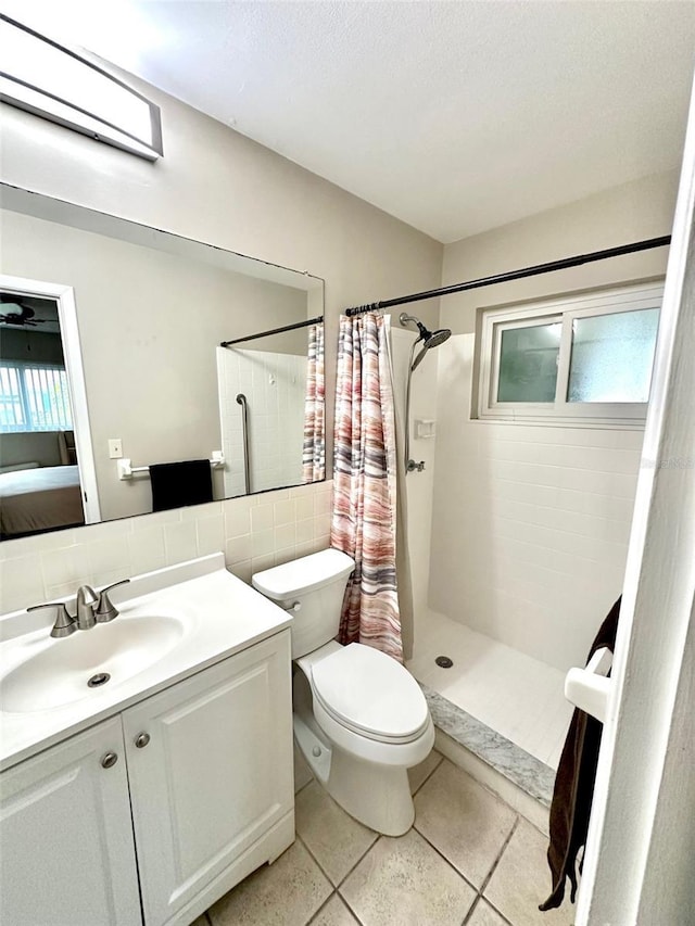 9830 44th Way N, Pinellas Park, FL 33782 - ensuite bathroom with vanity, a tile shower, backsplash, a textured ceiling, and tile walls