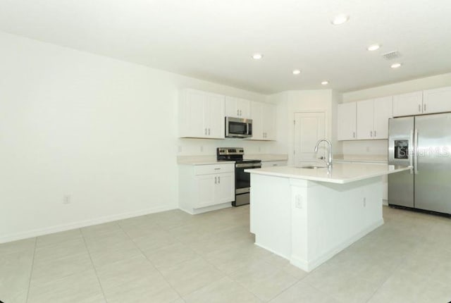 2555 Driftwood St, Auburndale, FL 33823 - kitchen featuring appliances with stainless steel finishes, recessed lighting, a kitchen island with sink, light countertops, and white cabinetry