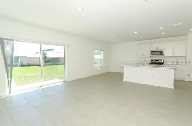 2555 Driftwood St, Auburndale, FL 33823 - kitchen with stainless steel appliances, recessed lighting, white cabinetry, light countertops, and open floor plan