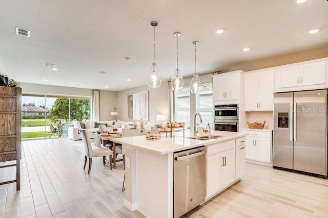2257 Cypress Creek St, Auburndale, FL 33823 - kitchen featuring stainless steel appliances, light countertops, light wood-style flooring, white cabinetry, and recessed lighting