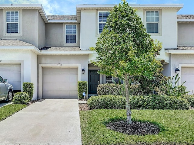 7133 Summer Holly Pl, Riverview, FL 33578 - traditional-style house with stucco siding, driveway, an attached garage, and roof with shingles