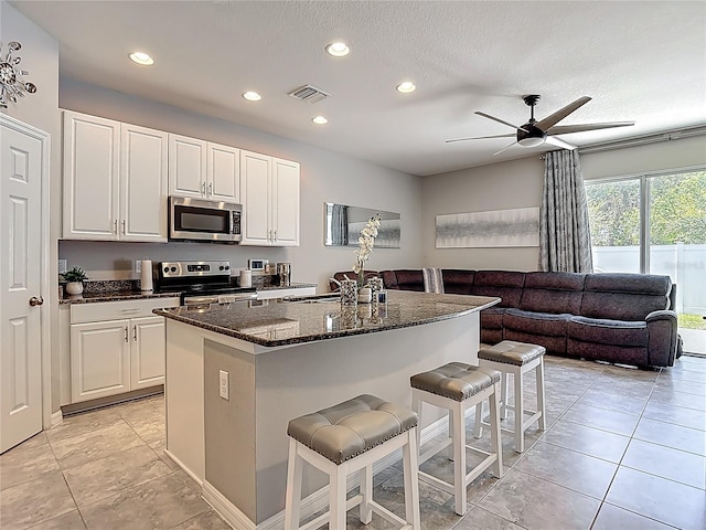 7133 Summer Holly Pl, Riverview, FL 33578 - kitchen with stainless steel appliances, a kitchen breakfast bar, recessed lighting, dark stone counters, and a ceiling fan