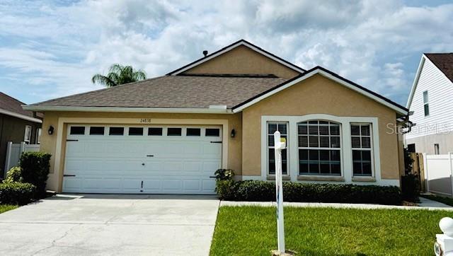 24838 Oakhaven Ct, Lutz, FL 33559 - single story home with stucco siding, driveway, a garage, and a front lawn