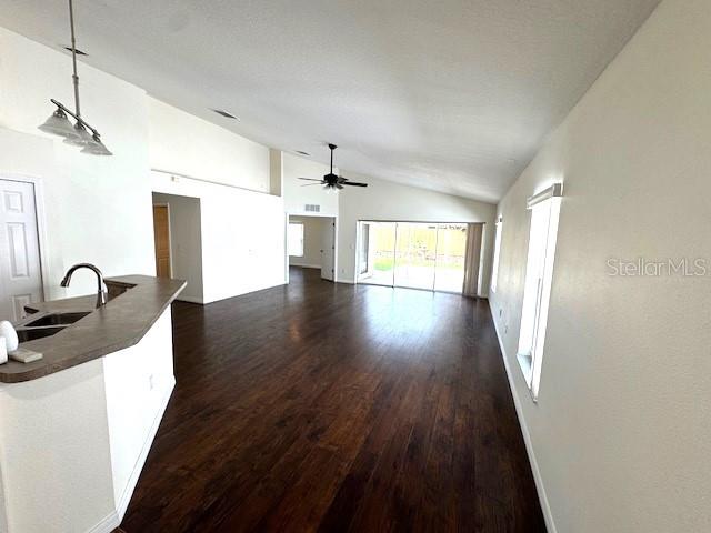 24838 Oakhaven Ct, Lutz, FL 33559 - unfurnished living room featuring lofted ceiling, a ceiling fan, and dark wood-type flooring