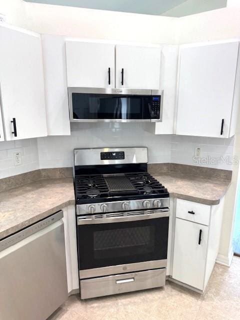 24838 Oakhaven Ct, Lutz, FL 33559 - kitchen with stainless steel appliances, white cabinetry, and tasteful backsplash