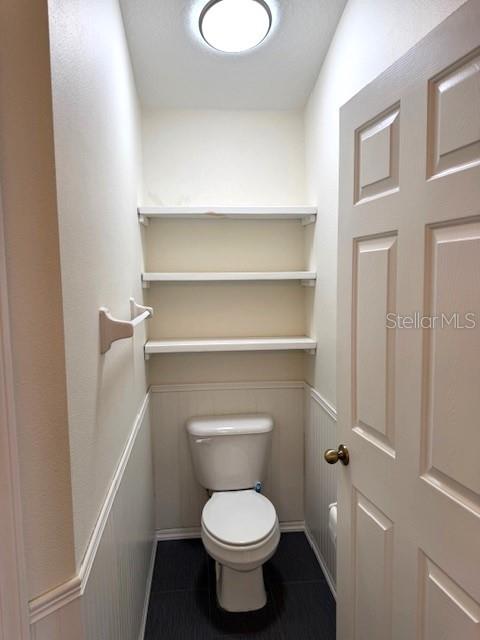 24838 Oakhaven Ct, Lutz, FL 33559 - bathroom with tile patterned flooring and a wainscoted wall