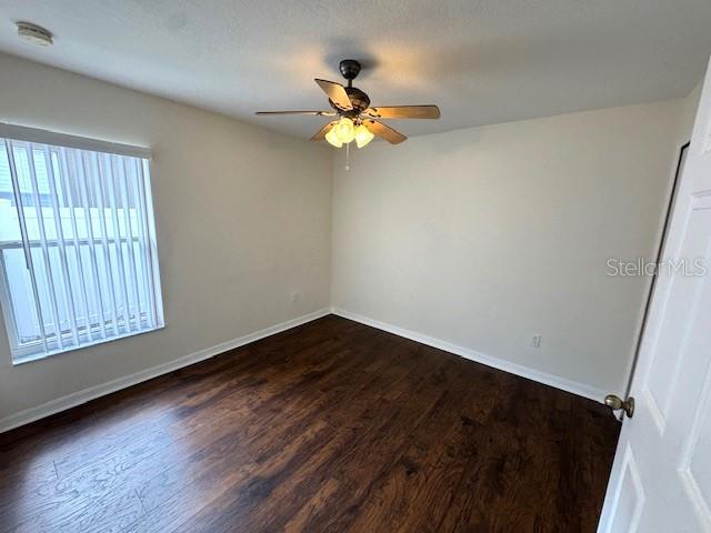 24838 Oakhaven Ct, Lutz, FL 33559 - empty room with ceiling fan and dark wood-style flooring