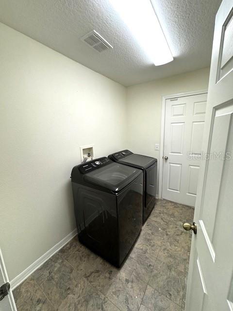 24838 Oakhaven Ct, Lutz, FL 33559 - laundry area featuring a textured ceiling and independent washer and dryer
