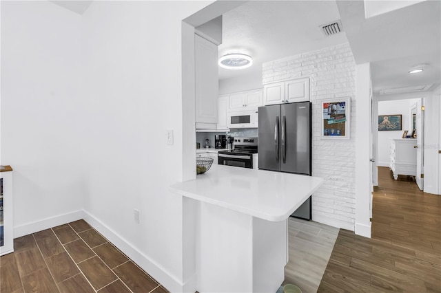 360 71st Ave, St Pete Beach, FL 33706 - kitchen featuring dark wood-style floors, light countertops, appliances with stainless steel finishes, and white cabinetry