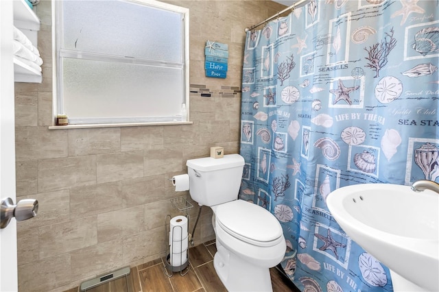 360 71st Ave, St Pete Beach, FL 33706 - bathroom with tile walls, wood finished floors, and a shower with curtain