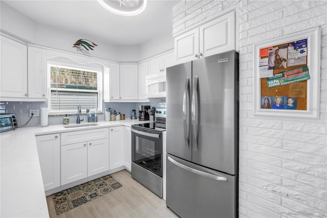 360 71st Ave, St Pete Beach, FL 33706 - kitchen featuring stainless steel appliances, white cabinetry, light countertops, and backsplash