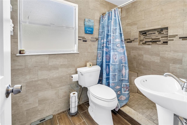 360 71st Ave, St Pete Beach, FL 33706 - full bathroom with tile walls, curtained shower, and wood finished floors