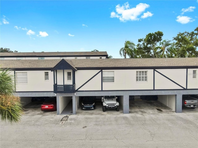 1146 King Arthur Ct Unit 114, Dunedin, FL 34698 - view of front of property featuring roof with shingles and covered parking