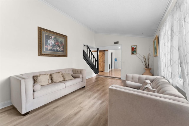 living area with stairway, ornamental molding, wood finished floors, and lofted ceiling