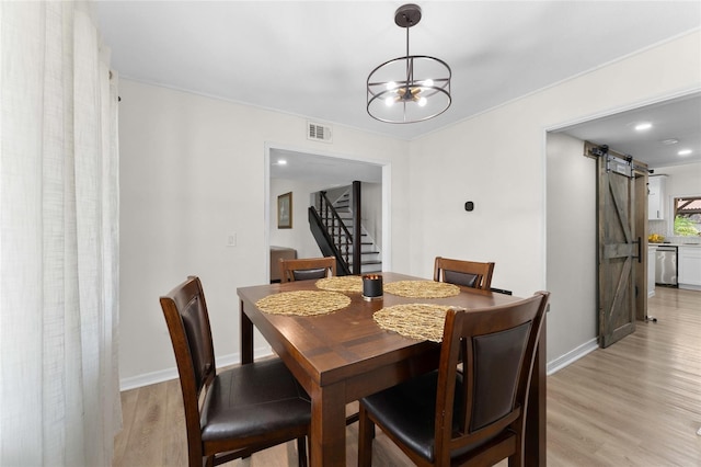 dining room featuring a barn door, a chandelier, light wood-style floors, stairway, and recessed lighting