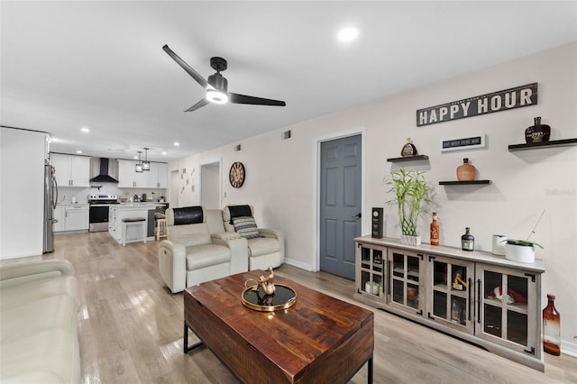 living area featuring a ceiling fan, recessed lighting, and light wood-style flooring