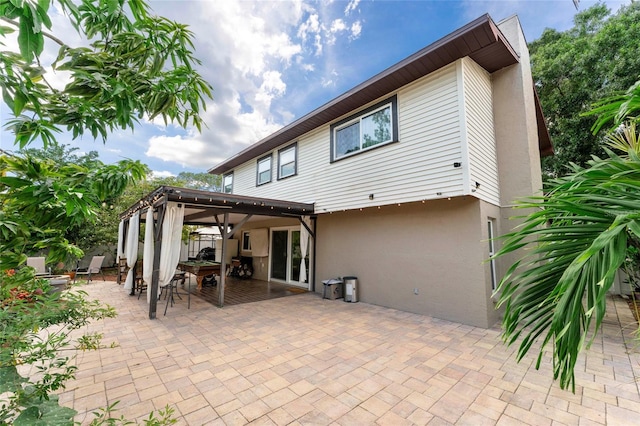 rear view of house featuring stucco siding and a patio