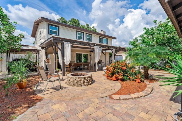 back of house with a fire pit, a patio, a chimney, and a gazebo