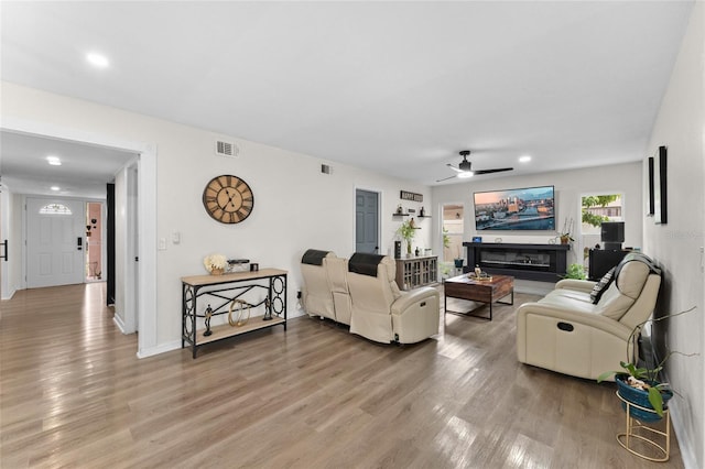 living area featuring ceiling fan, light wood finished floors, and recessed lighting
