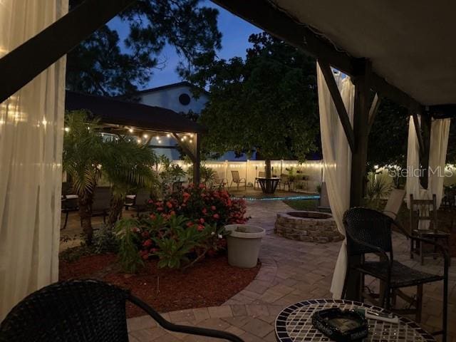 patio at twilight featuring a fire pit and a patio area