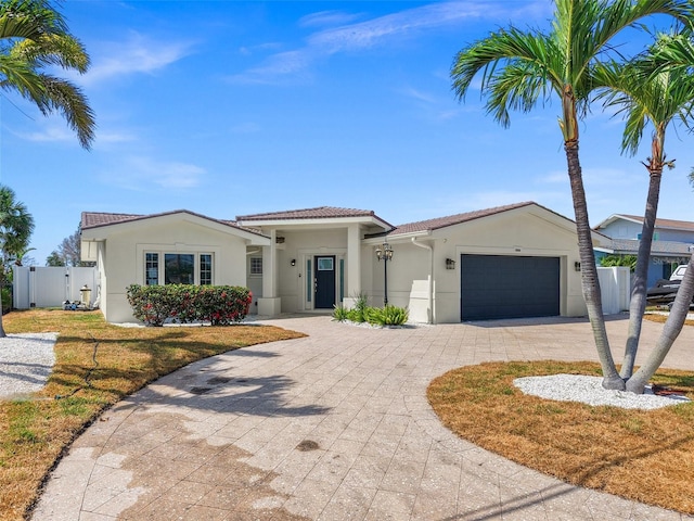 600 115th Ave, Treasure Island, FL 33706 - view of front of house featuring decorative driveway, stucco siding, an attached garage, and a tiled roof