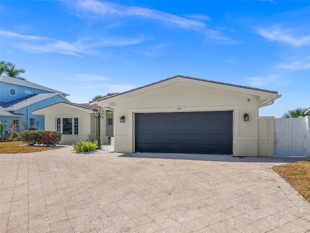600 115th Ave, Treasure Island, FL 33706 - ranch-style house with decorative driveway, an attached garage, and stucco siding