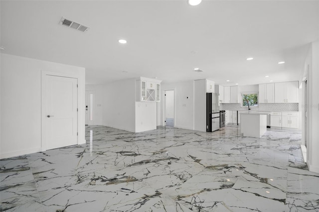 600 115th Ave, Treasure Island, FL 33706 - unfurnished living room with recessed lighting and light marble finish flooring