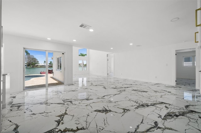 600 115th Ave, Treasure Island, FL 33706 - unfurnished room with light marble finish floors, recessed lighting, and a water view