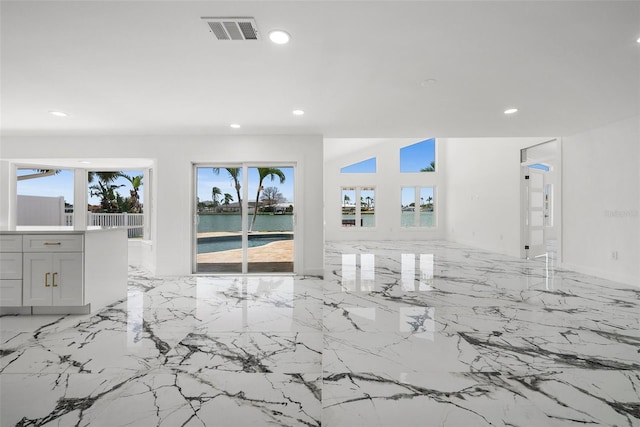 600 115th Ave, Treasure Island, FL 33706 - unfurnished living room featuring recessed lighting, light marble finish floors, and a water view