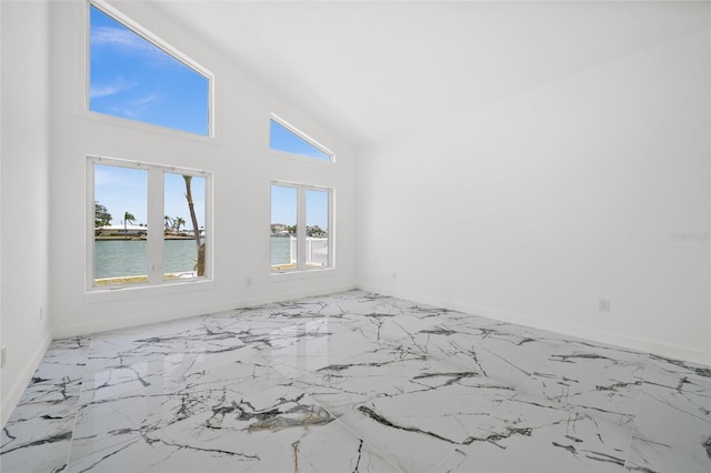 600 115th Ave, Treasure Island, FL 33706 - empty room featuring a water view, marble finish floors, and high vaulted ceiling