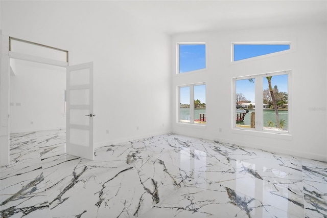600 115th Ave, Treasure Island, FL 33706 - empty room with a towering ceiling, healthy amount of natural light, and light marble finish floors