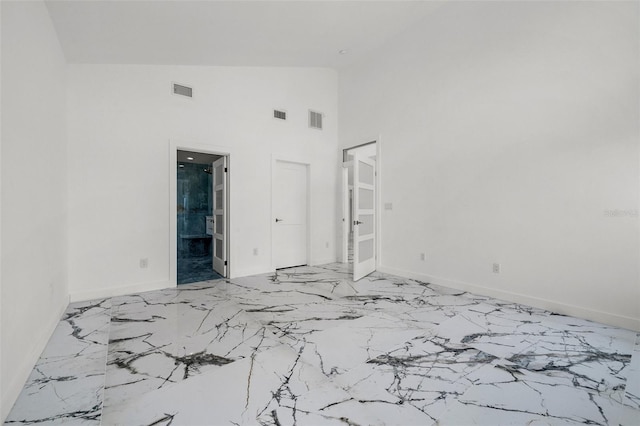 600 115th Ave, Treasure Island, FL 33706 - unfurnished room with light marble finish floors and high vaulted ceiling