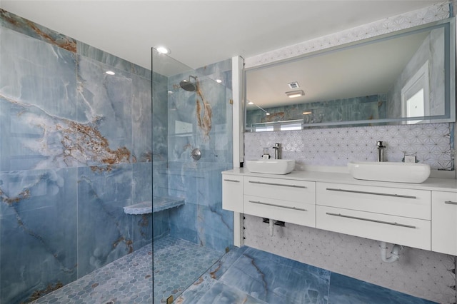 600 115th Ave, Treasure Island, FL 33706 - bathroom with a marble finish shower, tile walls, double vanity, and decorative backsplash