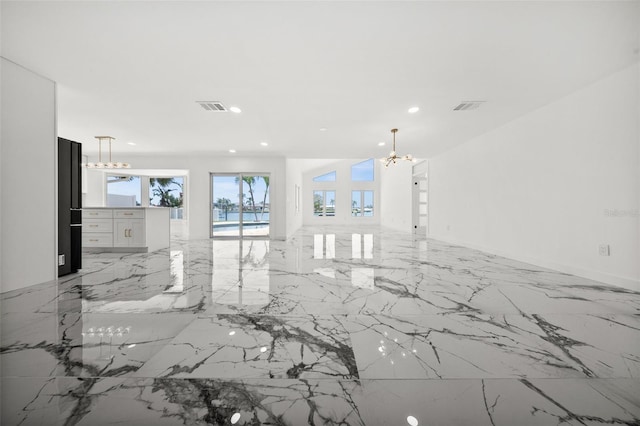 600 115th Ave, Treasure Island, FL 33706 - unfurnished living room with a chandelier, light marble finish flooring, and recessed lighting