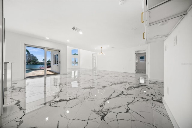 600 115th Ave, Treasure Island, FL 33706 - empty room featuring light marble finish flooring, a water view, recessed lighting, and a chandelier