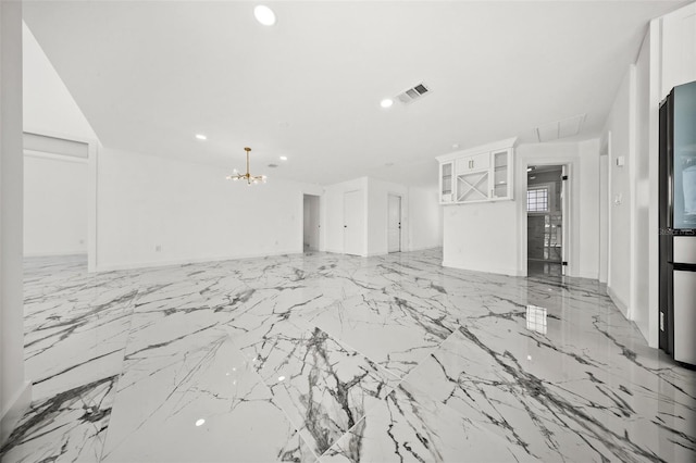 600 115th Ave, Treasure Island, FL 33706 - unfurnished living room with a chandelier, light marble finish floors, and recessed lighting