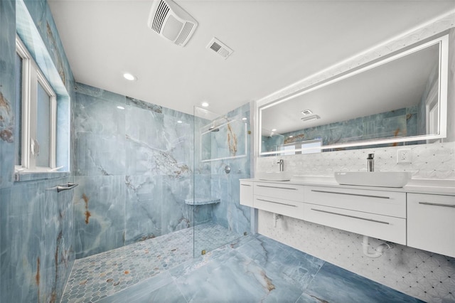 600 115th Ave, Treasure Island, FL 33706 - full bath featuring a marble finish shower, double vanity, tile walls, recessed lighting, and marble finish floors