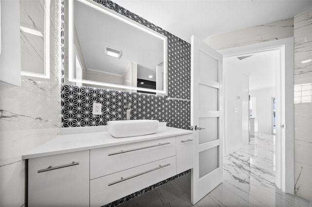 600 115th Ave, Treasure Island, FL 33706 - bathroom featuring vanity, marble finish floors, and tasteful backsplash