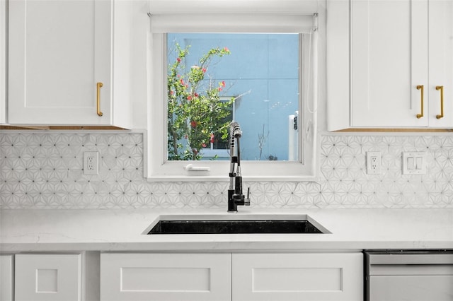 600 115th Ave, Treasure Island, FL 33706 - kitchen with white cabinetry, dishwasher, decorative backsplash, and light stone countertops