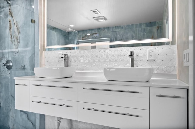 600 115th Ave, Treasure Island, FL 33706 - bathroom featuring tile walls, a stall shower, double vanity, and decorative backsplash