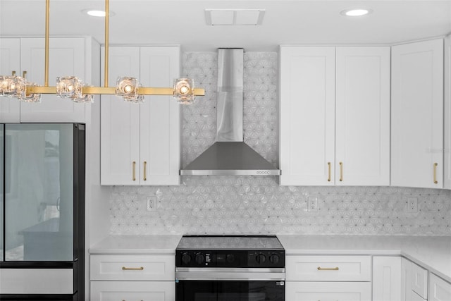 600 115th Ave, Treasure Island, FL 33706 - kitchen with electric range, wall chimney exhaust hood, freestanding refrigerator, light countertops, and white cabinetry