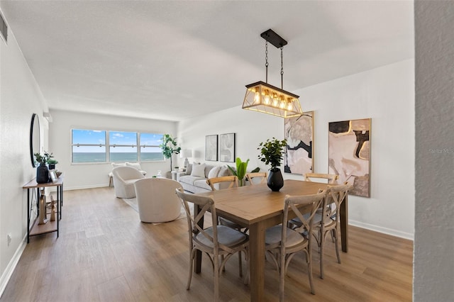 1230 Gulf Blvd Unit 1406, Clearwater Beach, FL 33767 - dining room featuring light wood-style floors and a chandelier