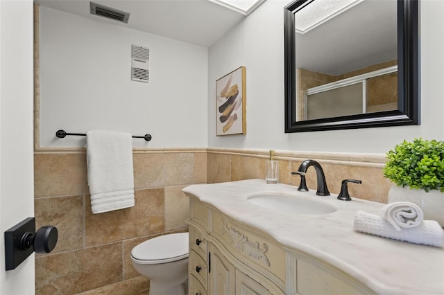 1230 Gulf Blvd Unit 1406, Clearwater Beach, FL 33767 - full bath with vanity, a shower with door, tile walls, and a wainscoted wall