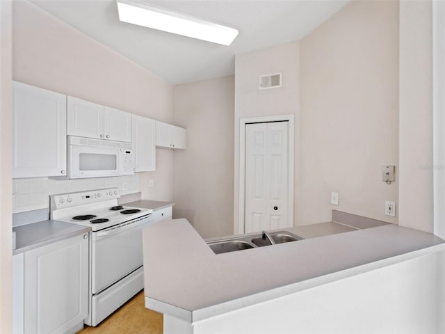 18107 Peregrines Perch Pl Unit 6302, Lutz, FL 33558 - kitchen featuring white appliances, a peninsula, white cabinets, decorative backsplash, and light countertops