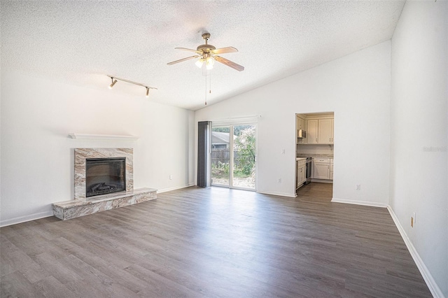 1902 Cedarbrooke Dr, Lutz, FL 33549 - unfurnished living room featuring a textured ceiling, a ceiling fan, a premium fireplace, dark wood-type flooring, and vaulted ceiling